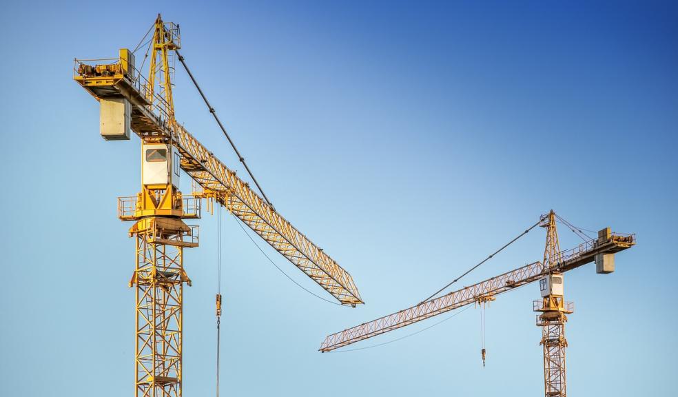 Cranes on a construction site in the summer A pair of cranes on a construction site