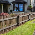 brown plastic fencing separating house front garden and driveway